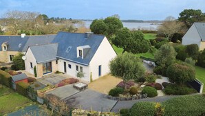 Un quartier résidentiel avec des maisons, une pelouse et un plan d’eau en arrière-plan.