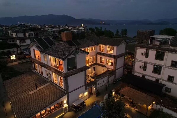 Un edificio de varios pisos con balcones, piscina y vista al agua.