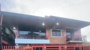 Un immeuble moderne doté d’un balcon, de grandes fenêtres et d’une entrée sécurisée par un portail.
