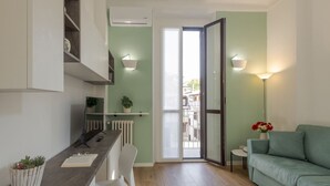 Eine moderne Küche mit Essbereich, einer Couch und Blick durch eine Glastür.