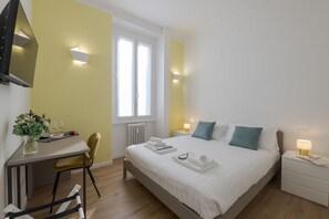 Ein Schlafzimmer mit Bett, Nachttischen, Schreibtisch und Stuhl.