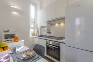 A modern kitchen with white cabinets, a stainless steel sink, a built-in oven, and a Samsung refrigerator. - Pomponazzi, 19 - Two-room apartment in the Bocconi area (Milano)
