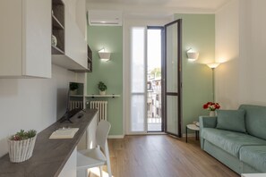 Una cocina moderna con comedor, sofá y vista a través de un ventanal.
