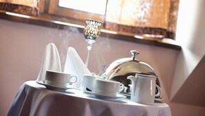 Una mesa con un calentador de té, tazas y un azucarero, vapor saliendo del calentador, indicando té caliente.
