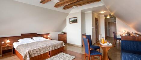 Un dormitorio con cama, una silla, una mesa y un escritorio.