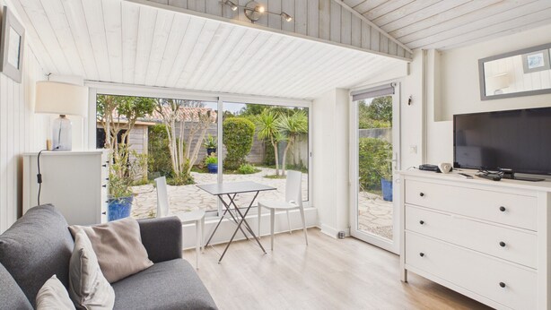 A modern living room with a sofa, a TV, and a dining area with a table and chairs. - Accommodation for 6, garden, near salt marshes (Ars-en-Ré)
