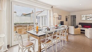 A dining area with a table, chairs, and a bottle of wine. - Accommodation for 6, garden, near salt marshes (Ars-en-Ré)