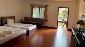 Une chambre d’hôtel avec deux lits, un banc, une fenêtre avec des rideaux et une vue sur l’extérieur.