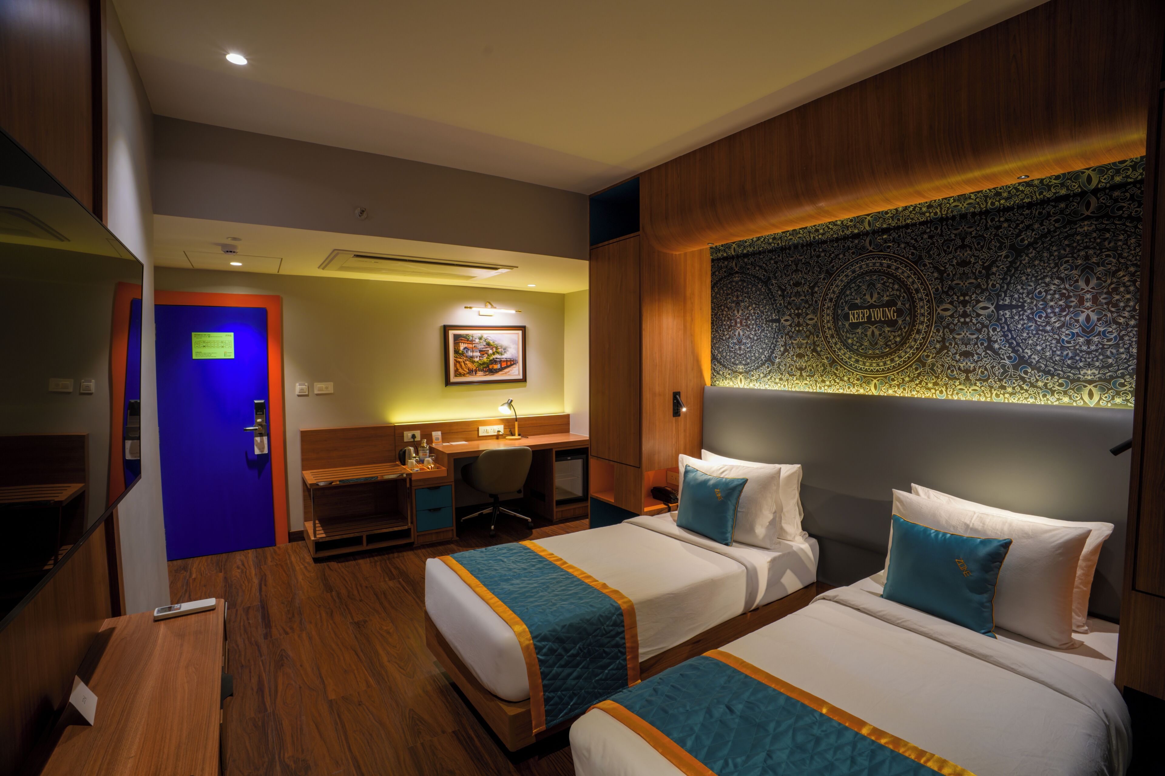 Habitación de hotel con dos camas, un escritorio y baño.