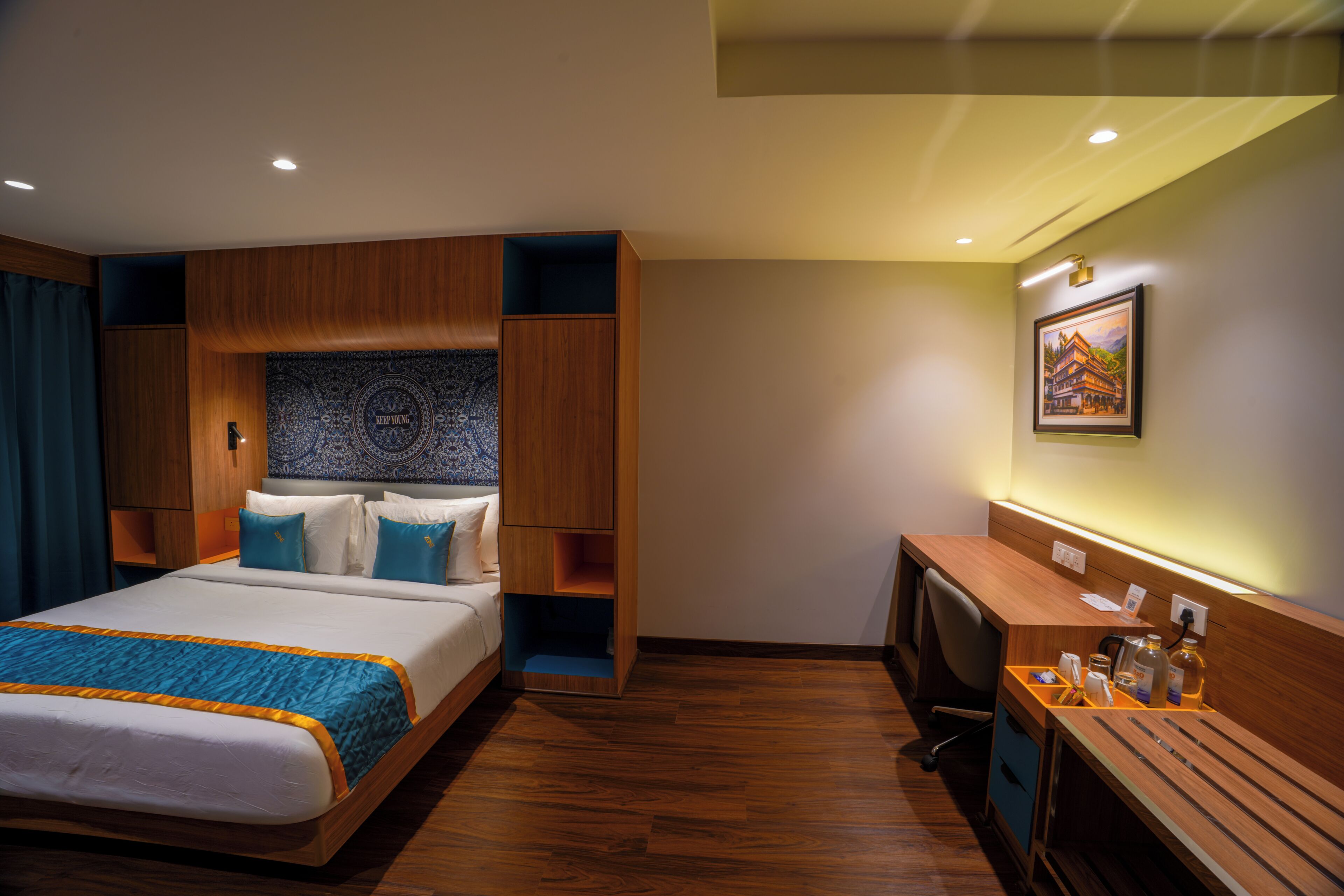 A hotel room with a bed, a desk, and a wall-mounted TV.