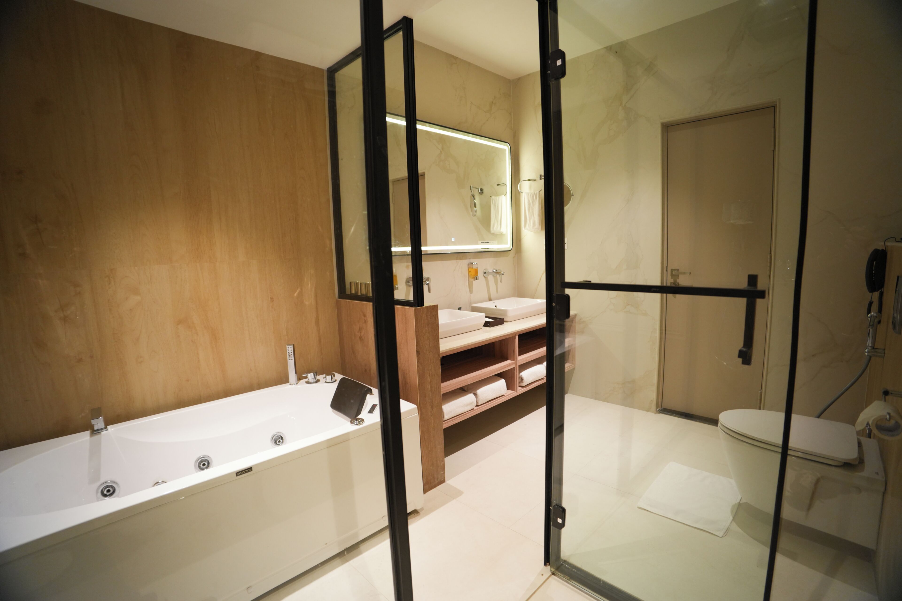 A modern bathroom with a bathtub, a toilet, and a shower area.
