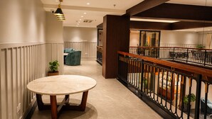 A hotel corridor with a marble-topped table, a blue chair, and a balcony with a railing. - Zone by The Park Darjeeling (Darjeeling)