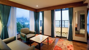 A modern living room with a sofa, chairs, a table, and a view of a cityscape through large windows. - Zone by The Park Darjeeling (Darjeeling)