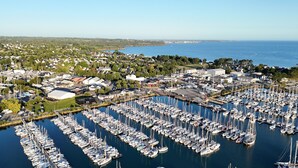 An aerial view of a marina with numerous boats docked, surrounded by residential buildings and greenery. - House for 6 adults and 3 children – 900m beach (La Forêt-Fouesnant)