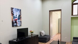 Ein modernes Wohnzimmer mit einem Flachbildfernseher auf einem schwarzen Schrank, einem Couchtisch und zwei Sofas.