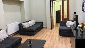 Ein modernes Wohnzimmer mit zwei Sofas, einem Couchtisch und einer TV-Konsole.