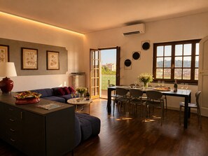 A modern living room with a sofa, a dining table set for four, and a kitchen area with a fridge and a stove. - Elegant 4-Bedroom Penthouse with an Elevator and 2 Parking Spaces in Florence (Florence)