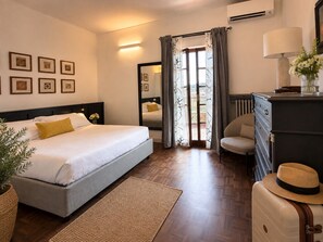A hotel room with a bed, a dresser, a mirror, and a view through a door. - Elegant 4-Bedroom Penthouse with an Elevator and 2 Parking Spaces in Florence (Florence)