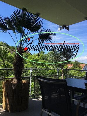 Un patio con una palmera, una mesa y sillas.