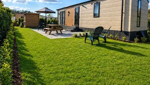 A modern mobile home with a patio area, a wooden deck, and a well-maintained lawn. - 4-Person Prins Chalet Hoogersmilde (Hoogersmilde)