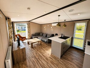 Ein modernes Interieur mit einer Couch, einem Couchtisch und einer Küchenzeile.