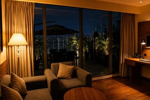 A modern hotel room with a large window, a sofa, a desk, and a lamp. - The Murti Hotel and Banquet (Greater Noida)
