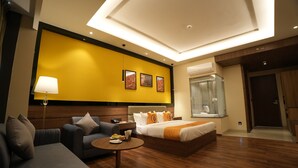 A modern hotel room with a bed, sofa, and a small table. - The Murti Hotel and Banquet (Greater Noida)