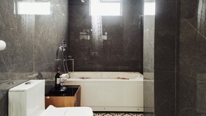 Ein modernes Badezimmer mit einer Badewanne, einer Dusche und einem WC.