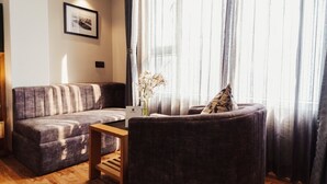 Ein modernes Wohnzimmer mit einer Couch, einem Sessel und einem kleinen Holztisch.