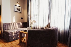 A modern living room with a sofa, armchair, and a small wooden table.