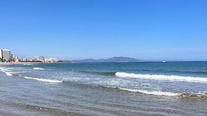 A beach with clear water, waves, and distant mountains. - Sweet Escape apartment on the beachfront (Orpesa)