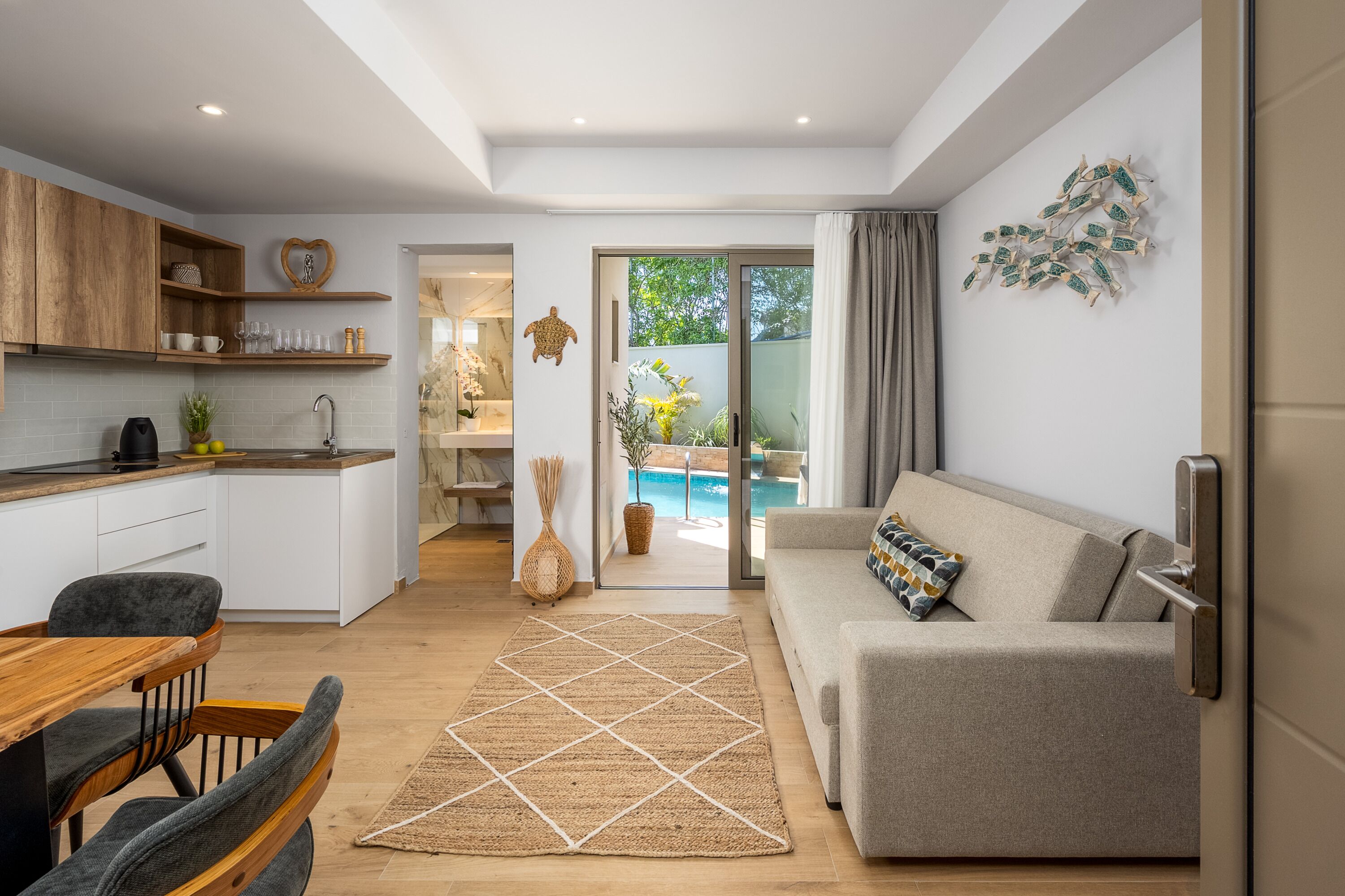 A modern living space with a kitchen, dining area, and a sofa.