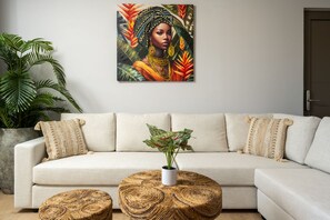 A living room with a sofa, a round wooden coffee table, and a potted plant. - Oasis Luxury Suites (Rhodes)