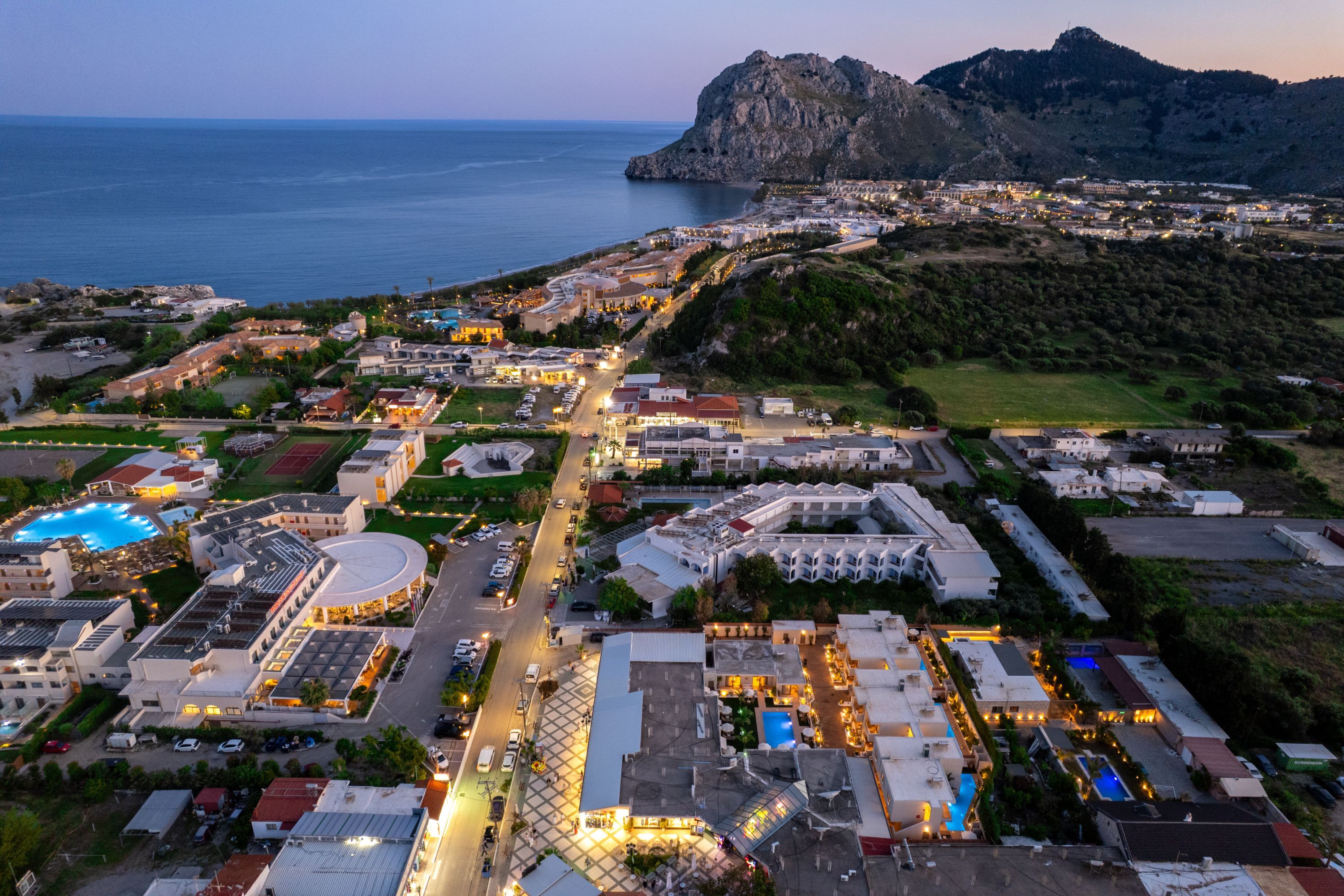 An aerial view of a coastal town with buildings, roads, and a large body of water.