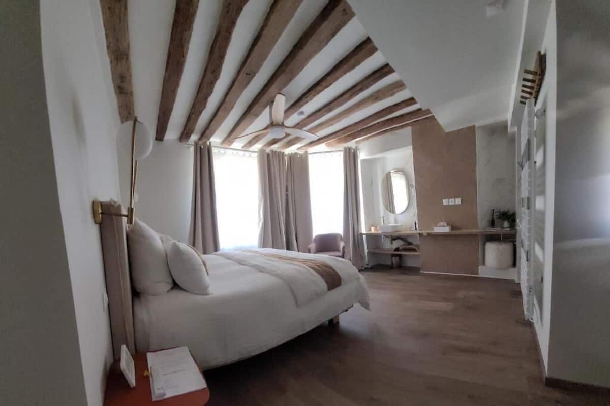A bedroom with a bed, a desk, and a chair.