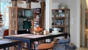 A modern interior with exposed wooden beams, a bar area, and a dining setup with bar stools. - Tresors de Sens  (Sens)