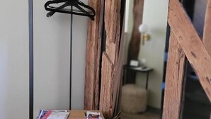 A wooden-framed room with a hanging black hanger and a wooden drawer unit. - Tresors de Sens  (Sens)