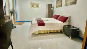 Un dormitorio con cama, armario, escritorio y silla.