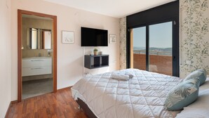 Une chambre avec un lit, une télévision, une fenêtre donnant sur un beau paysage et une salle de bain.
