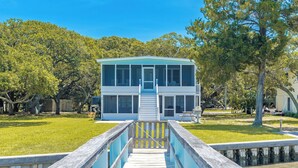 A two-story house with a front deck leading to a dock. - Register - A cozy 2-Bedroom Duplex with Soundfront Views for 6 Guests (Surf City)