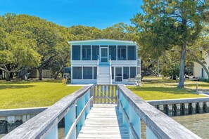 A two-story house with a front deck leading to a dock. - Register - A cozy 2-Bedroom Duplex with Soundfront Views for 6 Guests (Surf City)