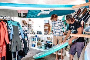 Un magasin de surf où l’on vend des planches de surf, des combinaisons de plongée et d’autres équipements.