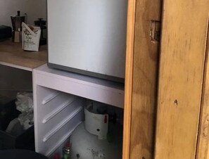 A kitchen with a refrigerator, a sink, and cabinets.