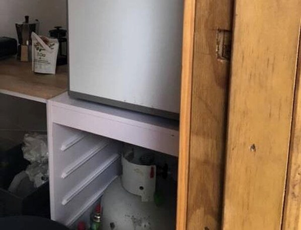 Una cocina con refrigerador, lavaplatos y gabinetes.