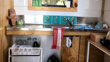 Coffee/tea maker, fridge, cookware/dishes/utensils, dining table