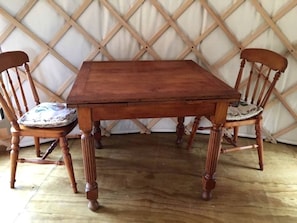 Une table de salle à manger en bois, accompagnée de quatre chaises, chacune dotée d’un siège rembourré.