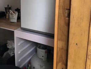 Keittiössä on jääkaappi, pesuallas ja kaappeja.