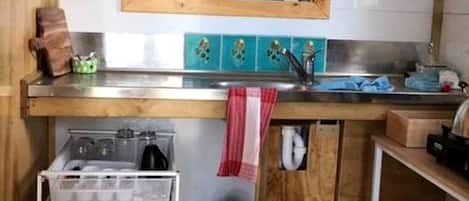 Una cocina compacta con ventana, un lavamanos y un horno pequeño.