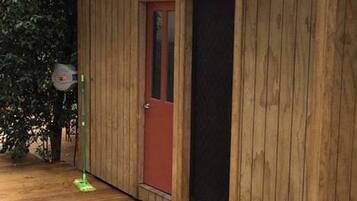 A wooden building with a red door and a window.