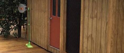 Un edificio de madera con puerta roja y ventana.